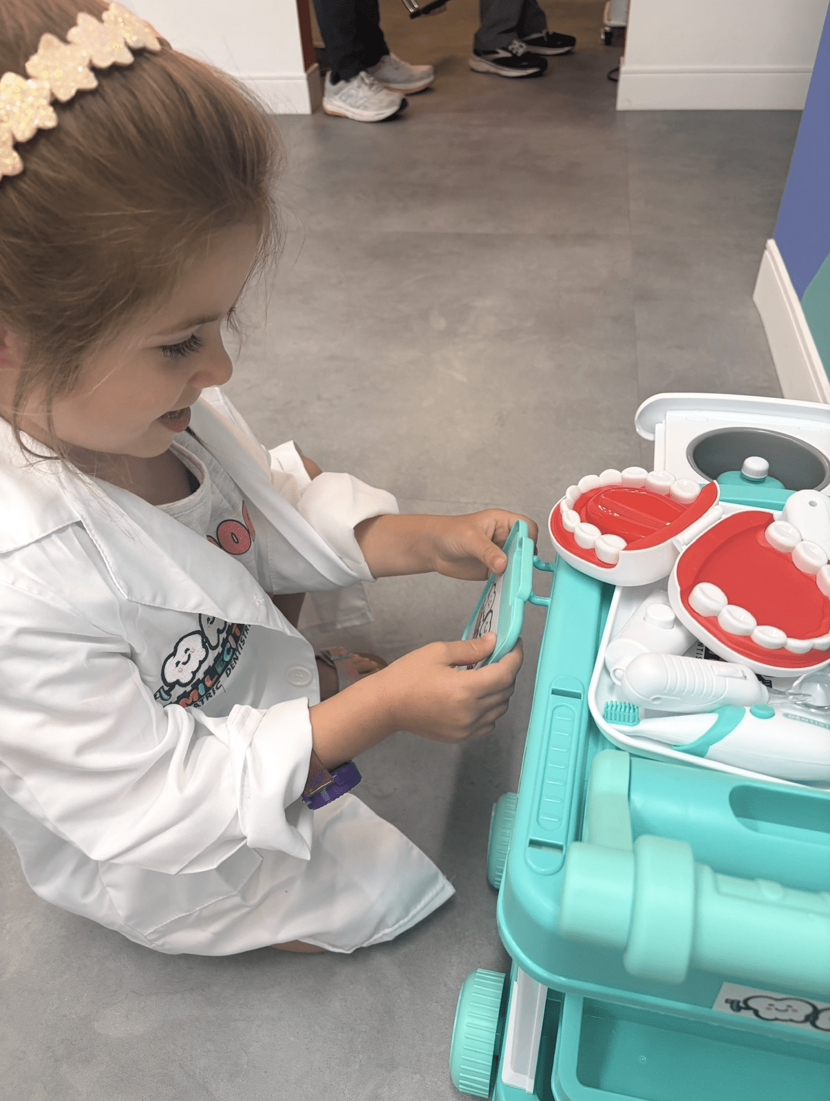 Child playing with a toy dental kit during a pediatric dental visit at SmileCity Pediatric Dentistry in Leesburg, VA